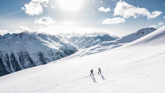 Zwei Skifahrer wandern auf einen Berg.